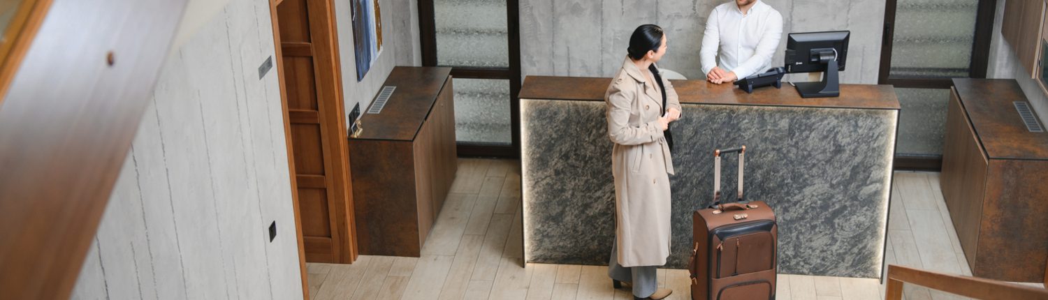 Female guests come with bags and suitcases to the hotel reception in the lobby